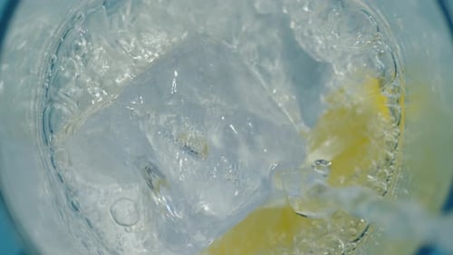 Soda Pouring Into Glass With Ice and Lemon