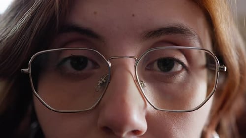 Une femme au look intellectuel ajuste ses lunettes