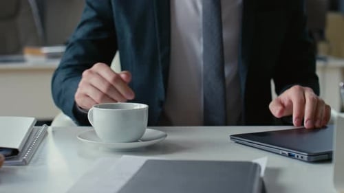 Business Person Types on Laptop in Modern Office