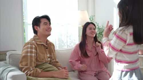 Happy Family Laughing and Hugging on Living Room Couch