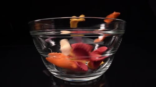 Colorful Uncooked Pasta Shells Being Poured Into Bowl