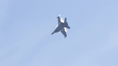 Fighter Jet Soaring Through Blue Sky