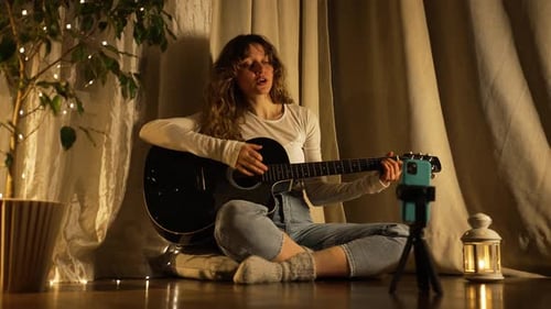 Woman Playing Guitar and Singing at Home