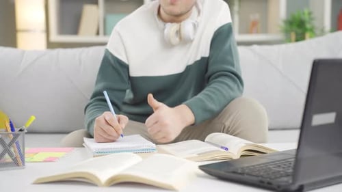 Young Adult Studying and Taking Notes at Desk