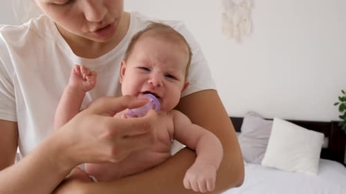 Mother Comforting Crying Baby with Pacifier