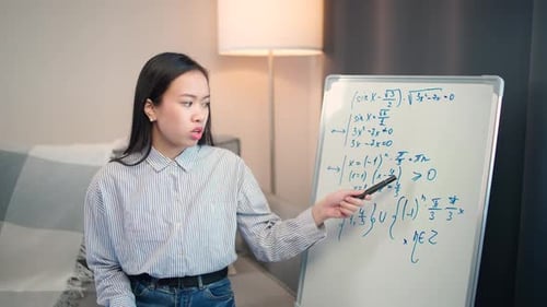 Young Woman Teaches Math on Whiteboard at Home