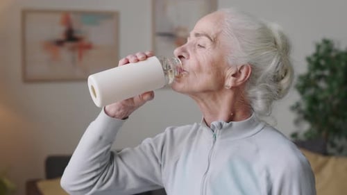 Senior Woman Drinking Water after Home Workout