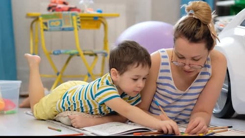 Woman and Child Lying on Rug Coloring Together