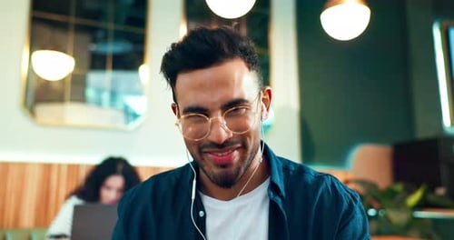 Online meeting, man in coffee shop with earphones and video call, networking and yes in remote work