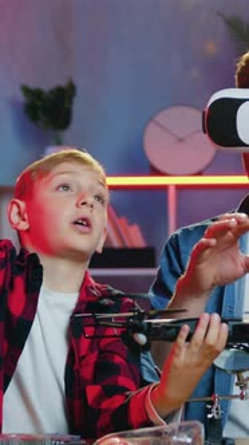 Boy Watching Man Use VR with Drone Indoors