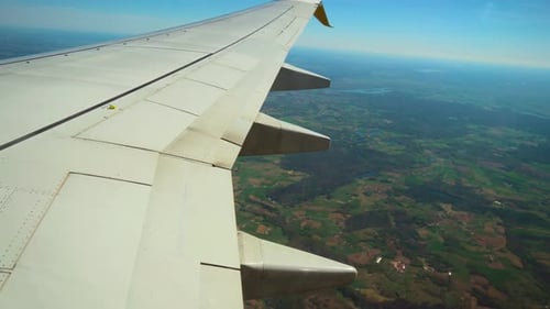 Flugzeug beim Abstieg über grüne Landschaft mit verstreuten Seen, Flugzeug senkt die Höhe darüber
