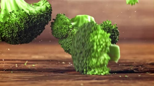 Broccoli Florets Falling in Slow Motion onto Wood