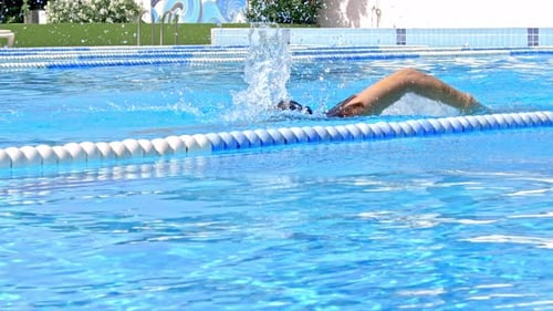 Focused Swimmer Training Freestyle in Outdoor Pool