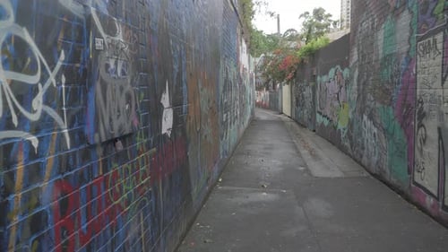 Beco vazio com grafites coloridos na parede de concreto - foto lateral