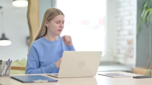 Young Adult Woman Coughing at Computer