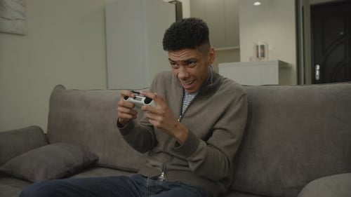 Young Adult Playing Video Games on Couch