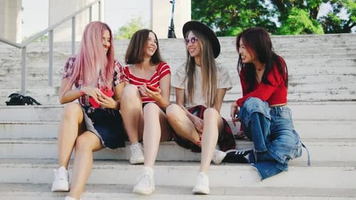 Stylish Friends Chatting on Concrete Urban Steps