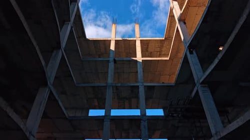 Empty space inside the building under construction. Rebars are on the roof of the structure.