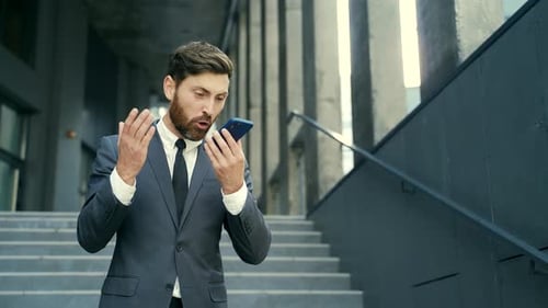Man in Suit Talking Angrily into Mobile Phone