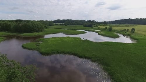 An einem bewölkten Sommertag fuhr das Boot auf einem gewundenen Fluss ab. Dolly-In-Schuss aus der Luft