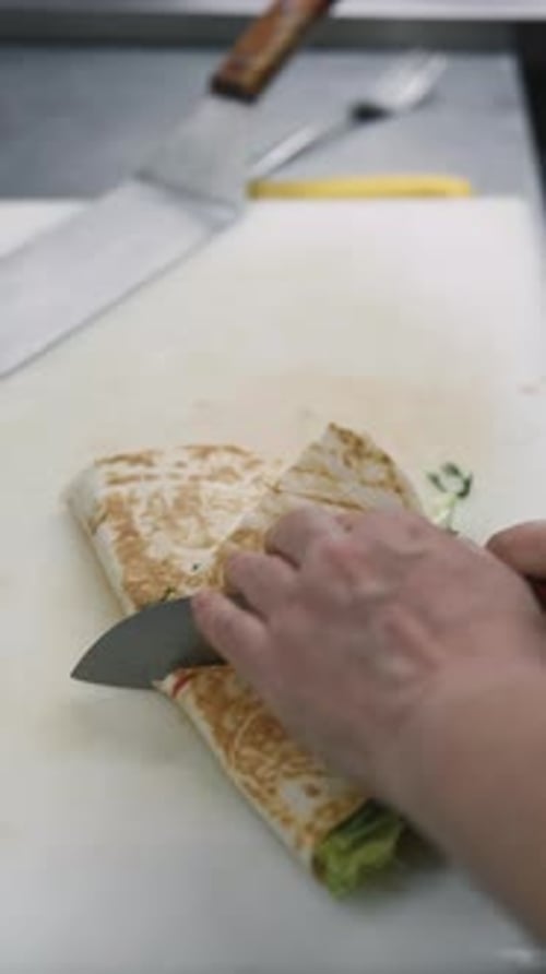 Chef Cuts Grilled Wrap on Cutting Board