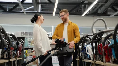 Couple Choosing Vacuum Cleaner in an Electronics Store for New Home