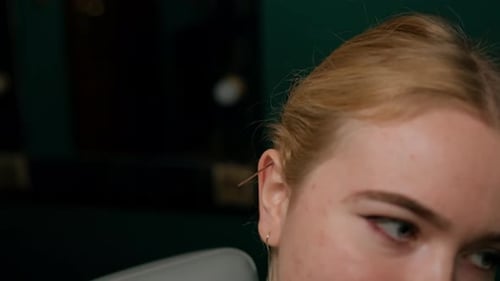 Piercing studio interior - piercing master makes a piercing to a girl, ear piercing