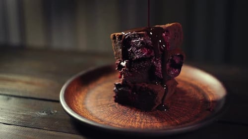 Chocolate Sauce Poured Over Brownies Stacked on Plate