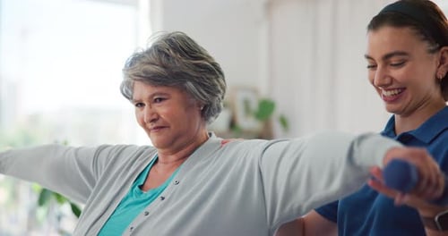 Senior Woman Exercising with Young Adult Assistant