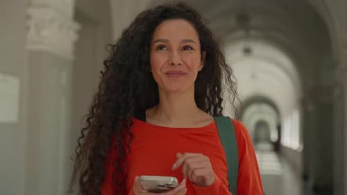 Happy Hispanic Student Girl Walking University Corridor Smiling Using Smartphone Female Woman