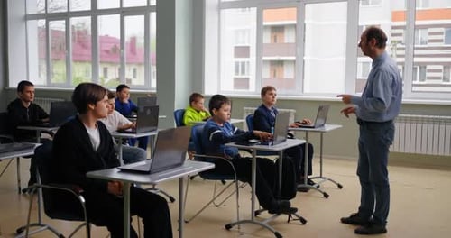 Professional Teacher Speaking With Young School Students In Computer Classroom Coding Classes