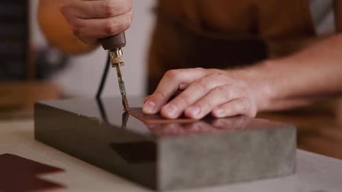 Close Up Of Man Working Leather With Small Tool