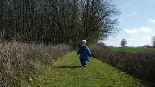 Infant Walking on Grassy Path in Rural Setting