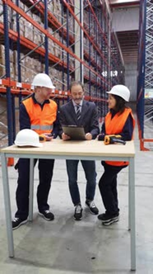 Warehouse Workers Discussing Logistics Management