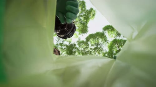 Vista inferior e interior de voluntarios que arrojan basura plástica a un saco