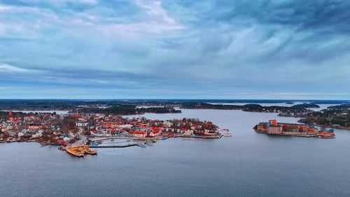 Flying over Lake Malar reflecting overcast grey sky. Aerial perspective on the bright cityscape