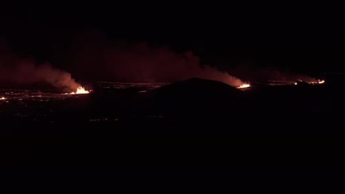 Aerial video of distant lava trail, volcano eruption in Iceland, Europe