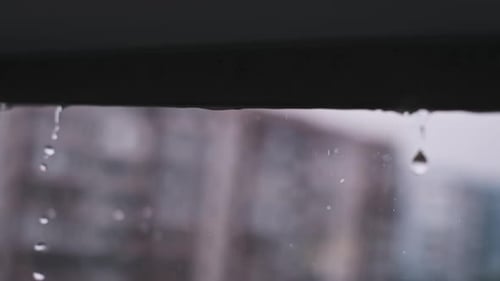 Raindrops Falling From Ledge in Urban Setting