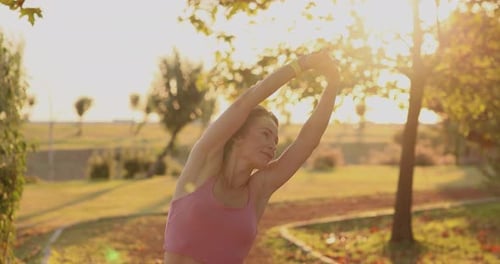 Fit sportswoman working out outdoors in autumn park