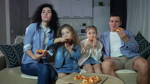 Family Enjoys Pizza Together on Couch at Home