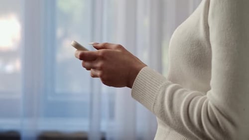 Woman Using Mobile Phone in Bright Indoor Setting