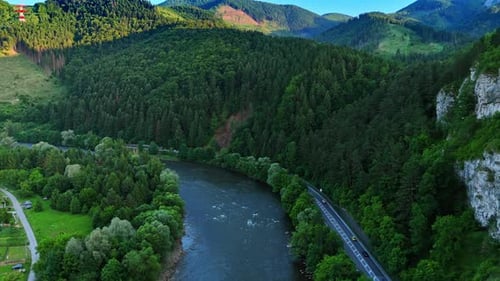 River flowing through mountain valley with forest slopes.