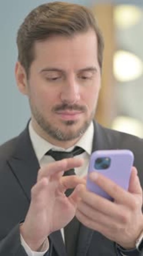 Man in Suit Using Smartphone Indoors, Vertical Format