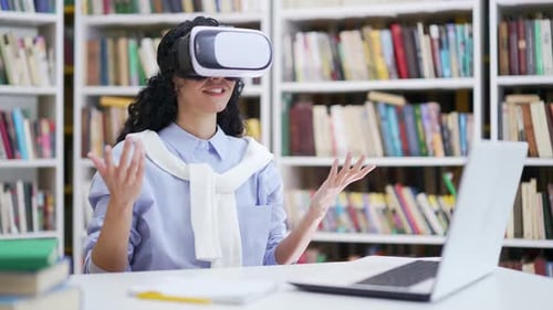 Successful female student using virtual reality glasses for video call and online chat in virtual