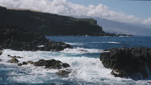 A Big Waves of the Atlantic Ocean Breaks on a Rocky Coast on a Sunny Day During a Storm in in the