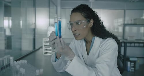 Close-up Female scientist Holding Chemical Test Tubes in Laboratory