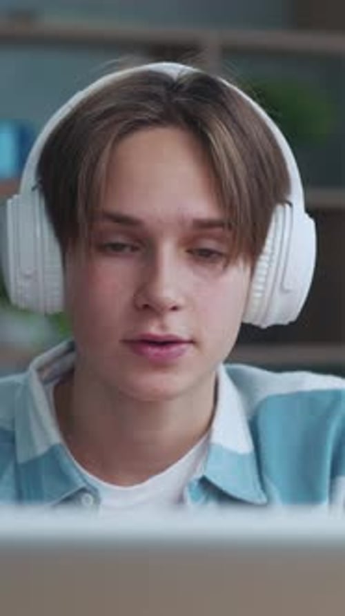 Young Adult with Headphones Looking at Screen