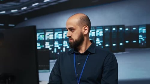 Adult Coding at Computer in Data Center