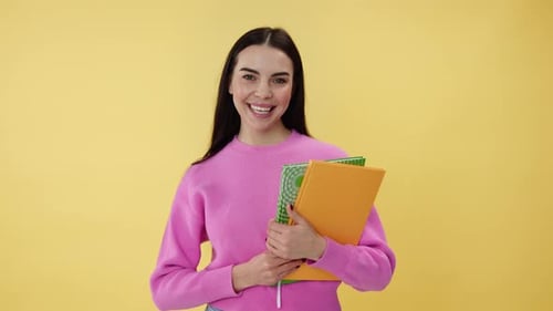 Smiling Woman Holding Notebooks in Studio