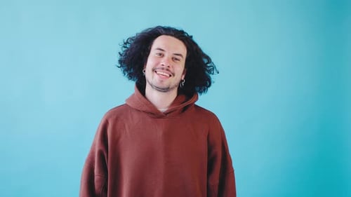 A Confident Young Man in a Brown Hoodie Exudes a Trendy Carefree Vibe with a Modern and Relaxed Aura